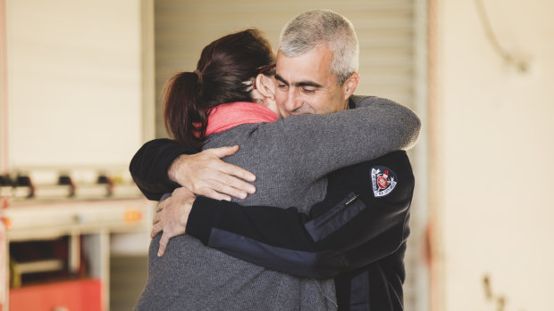 Tim Wimborne and Alanna Davis embrace on Saturday. Mr Wimborne stayed with Ms Davis while the fire crew rescued TJ.
