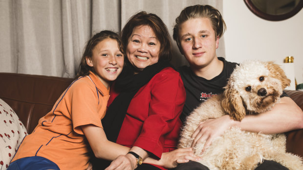Mila Angcon with two of her grandchildren Rebecca, 12, and Riley, 15, and their dog Malakai. 