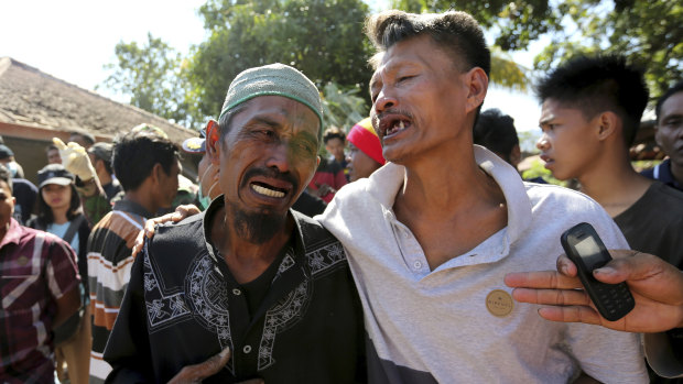 Relatives react as rescue teams recover the bodies of victims killed in an earthquake in North Lombok.