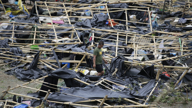 A policeman walks through makeshift tent shelters damaged by strong winds from Typhoon Mangkhut after it barreled across Tuguegarao city in Cagayan province, north-eastern Philippines on Sunday.