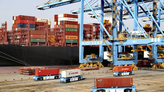 Rising giant: Automated vehicles move shipping containers at a port in China’s Shandong province.