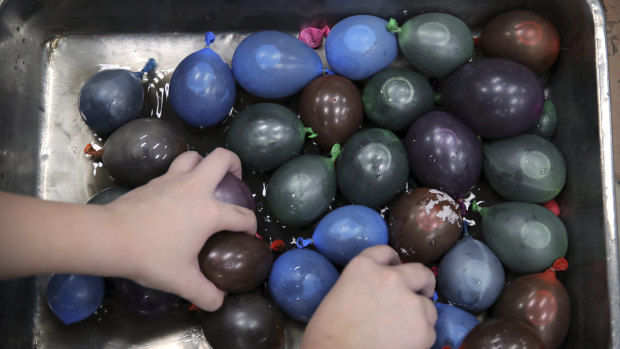 A protester fills balloons with paint and water at the Hong Kong Polytechnic University on Friday.