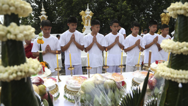 Eleven of the boys and their coach  attend the merit-making ceremony at a Buddhist temple.