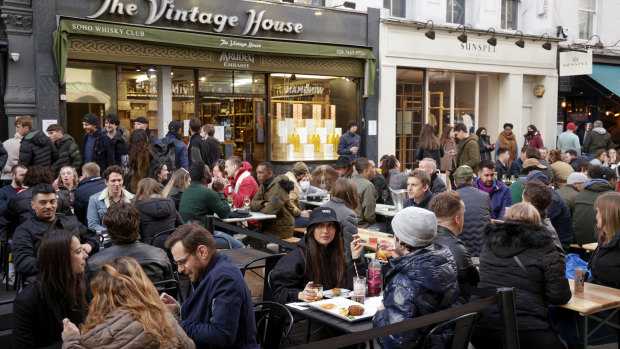 Customers dine in an outdoor seating area of a restaurant in Soho in London.