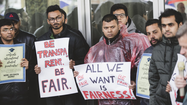 International students protest outside the Legislative Assembly against changes to the ACT government's visa program.