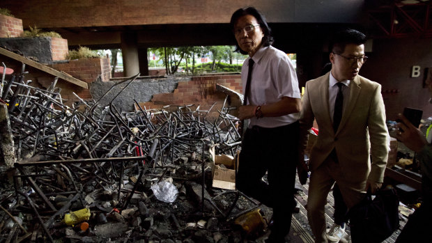 Gary Fan Kwok-wai, newly elected district councillor, right, and lawyer Wong Kwok Tung, left, walk through burnt debris as they try to meet with the last of trapped protesters at the Polytechnic University in Hong Kong on Monday.