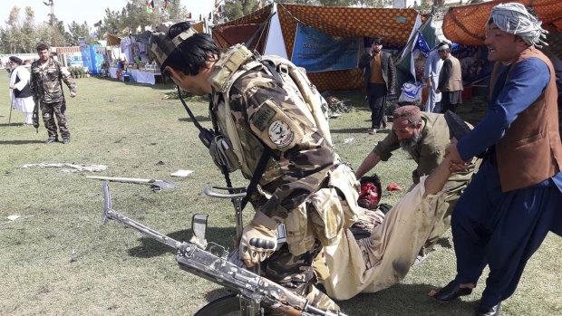 A wounded man is tended to following multiple explosions in Lashkar Gah city of Helmand province, southern Afghanistan, on Saturday.