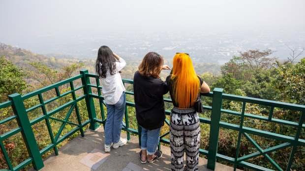 Tourists look out over the dense haze covering Chiang Mai.