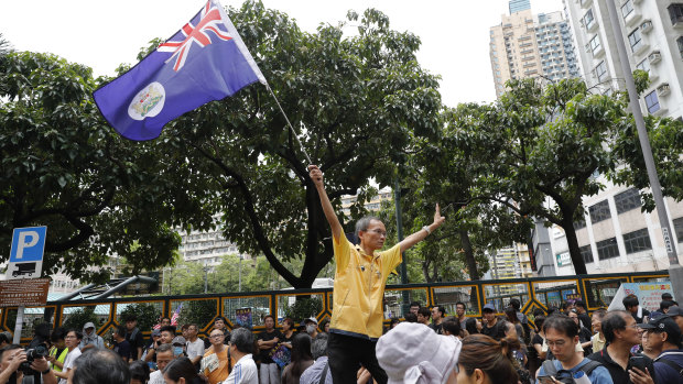 A protester waves a colonial British-era Hong Kong flag.