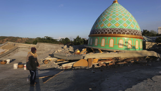 Locals view the devastation of a collapsed Jamiul Jamaah Mosque in Bangsal, North Lombok, Indonesia.