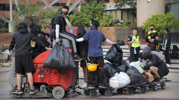 Protesters who had barricaded themselves in a Hong Kong university this week began to leave Friday after partially clearing a road they had blocked.