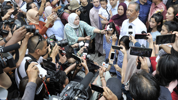 Muhyiddin Yassin, second in white shirt, talks to the media after being appointed as new prime minister.