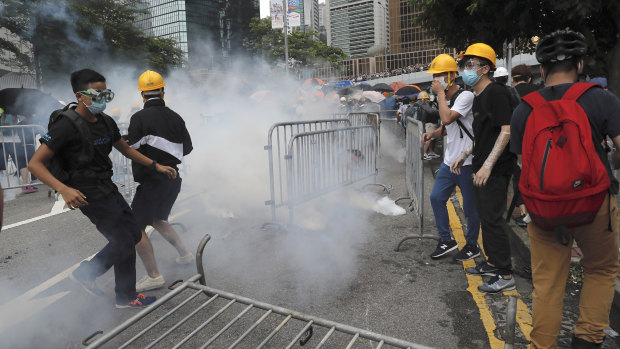 Protestors react to tear gas during a large protest near the Legislative Council in Hong Kong on Wednesday.