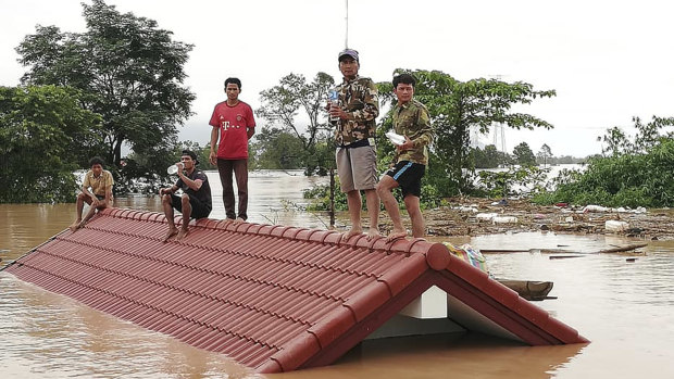 Villagers take refuge on a rooftop above flood waters from a collapsed dam in the Attapeu district of south-eastern Laos.