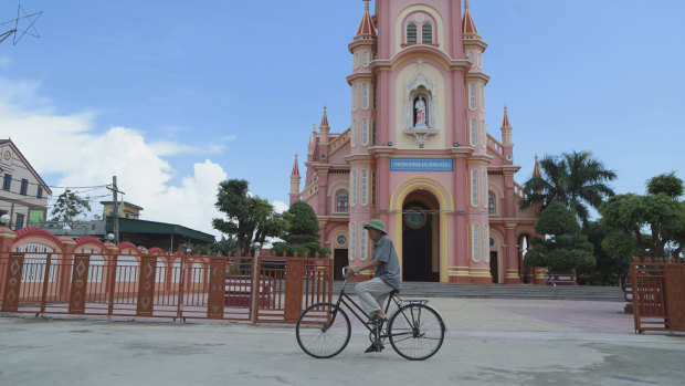 A man rides his bicycle past a Catholic church in the Dien Thinh village from where many of the victims came from.