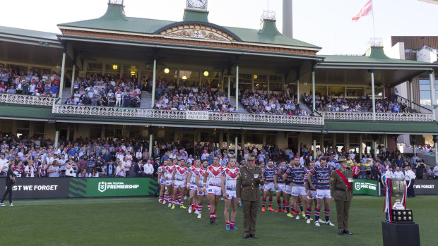 Solemn: both teams line the Sydney Cricket Ground turf before the match between Sydney Roosters and the Dragons.