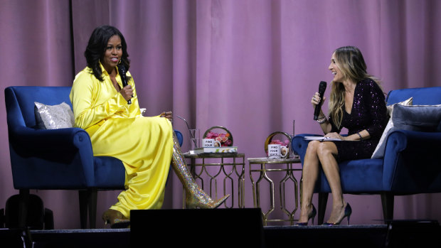 Former first lady Michelle Obama, left, is interviewed by Sarah Jessica Parker during an appearance for her book, Becoming.