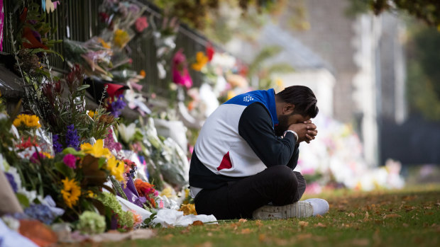 Deepak Sharma takes a quiet moment of contemplation at a makeshift shrine of flowers at the Botanical Gardens in Christchurch, 17th March 2019. 