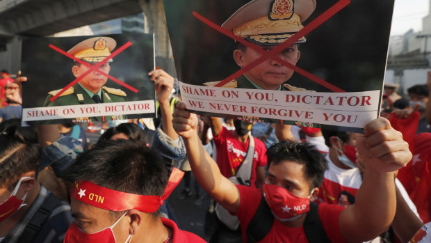 Burmese living in Thailand hold pictures of Myanmar military Commander-in-Chief Senior Gen. Min Aung Hlaing during a protest in front of the Myanmar Embassy, in Bangkok, Thailand.