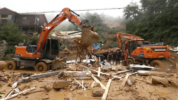Rescue workers use heavy equipment to search for survivors in a collapsed house in Gapyeong, South Korea.
