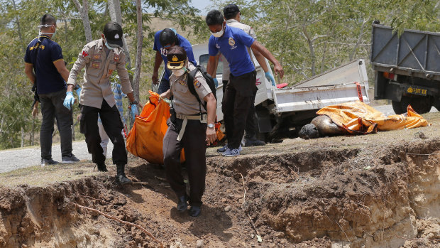 The body of a tsunami victim is taken to a mass burial site in Palu, Sulawesi, on Monday.