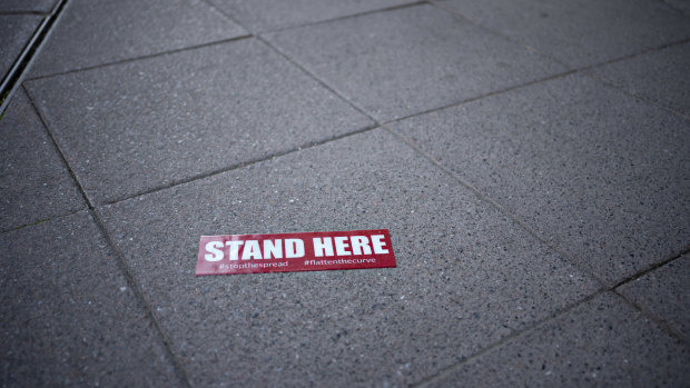 Stand Here signage sits on the sidewalk outside a restaurant in Washington, DC.