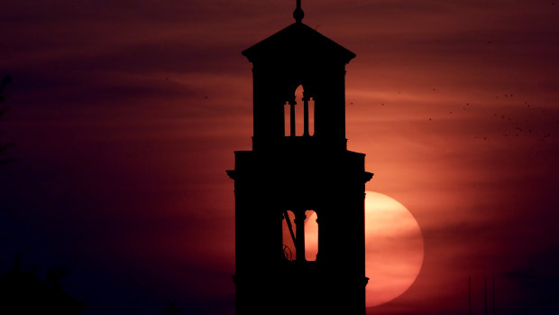 Our Lady of Sorrows Catholic Church is silhouetted against the rising sun in Kansas City, Missouri.
