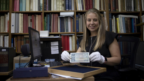 Charlotte Noble holds a rare £100 banknote issued in 1914. 