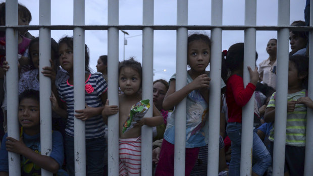 Migrant children bound for the US-Mexico border wait on a bridge that stretches over the Suchiate River, connecting Guatemala and Mexico, in Tecun Uman, Guatemala, on Friday.