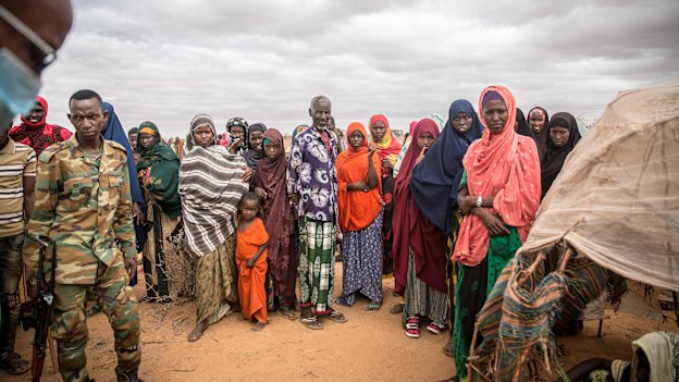 People displaced due to the drought stand around in a camp on the outskirts of Dollow, Jubaland, in Somalia hoping for aid and assistance.