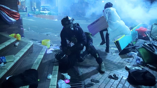 A policeman detains a protester outside of Hong Kong Polytechnic University as police storm the campus  on November 18.