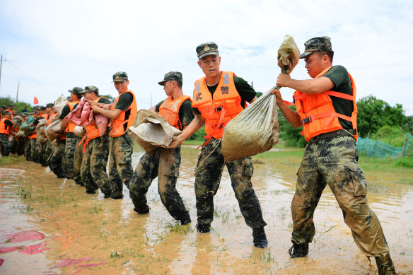 Paramilitary police form a line to move sandbags to reinforce a dyke along the banks of Poyang Lake in Poyang County in eastern China's Jiangxi province on Sunday.