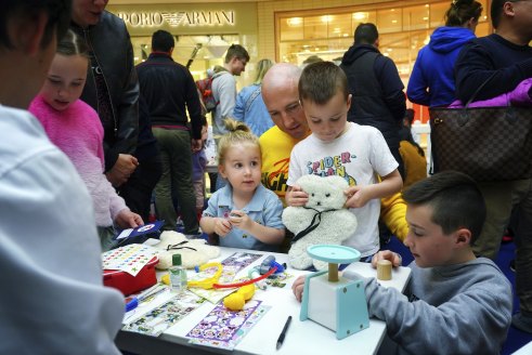 Here for first aid: Aston Teather holds  teddy bear Marshall as his parents and three siblings look on.
