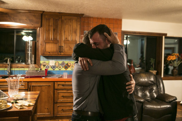 Tyler Johnson, right, whose wife, Christina Langford Johnson, was among those killed in an ambush, embraces a family member.