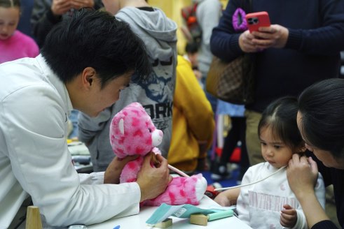 Check up: a student doctor examines Beatrix Elisse Garcia’s teddy, Beatrice, as Mum Christine looks on.