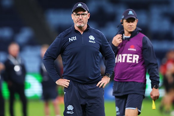 Dan McKellar watches on in the Waratahs warm-up, with trainer Tom Carter in the background.