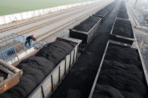 A worker shovels up coal on a freight train in Huaibei, Anhui province, in January.