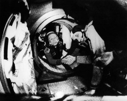 Thomas Stafford (right) shakes hands with cosmonaut Alexei Leonov in the docking tunnel between Apollo and Soyuz in July 1975.