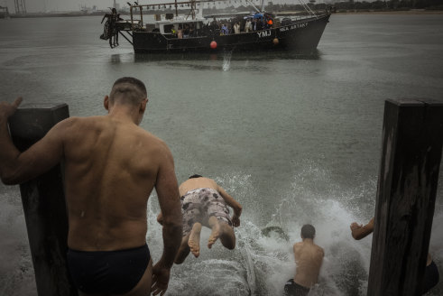 Swimmers dived off Princes Pier and swam out after the bishop threw the cross off a fishing boat.