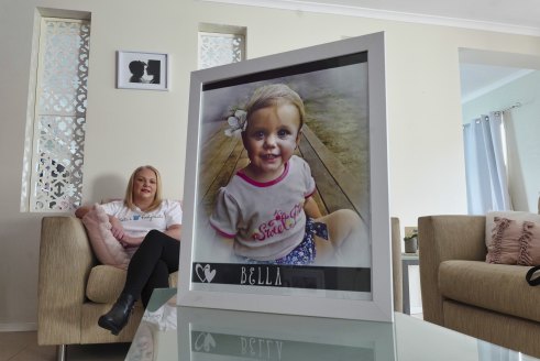 Allison Burns, OAM, with a photo of her daughter, Bella Rees, who died after swallowing a button battery.