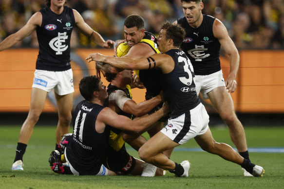 Jack Graham is tackled by Charlie Curnow.