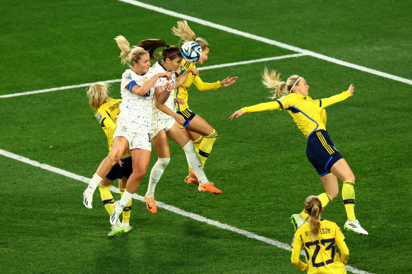 Alex Morgan heads the ball towards the goal.