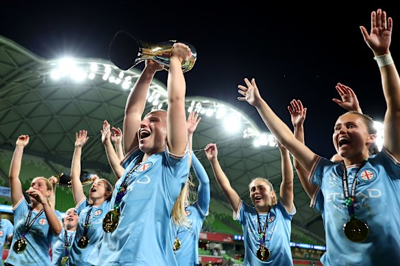 Holly McNamara and her teammates celebrate with the trophy.