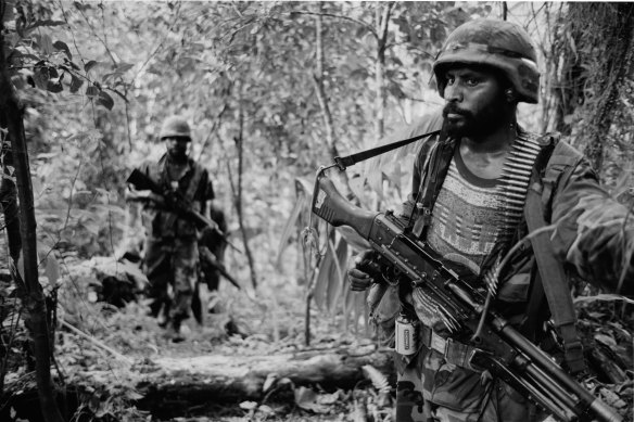 PNG army troops on patrol in heavy jungle in 1997, hunting for guerillas who had shot a boy dead nearby.