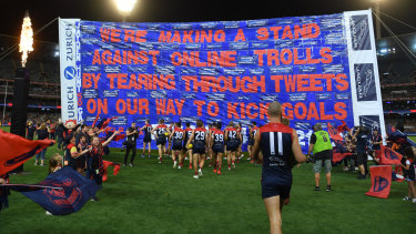 The Demons run through their banner on Friday night.