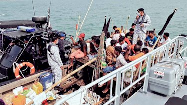 Malaysian navy officers detain a boat carrying Rohingya migrants off Langkawi, Malaysia, last week.