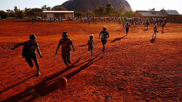 Mutitjulu children playing footy during the closing ceremony in the shadow of Uluru.