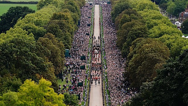 Crowds at Windsor watch as the Queen’s hearse appraoches the castle. 