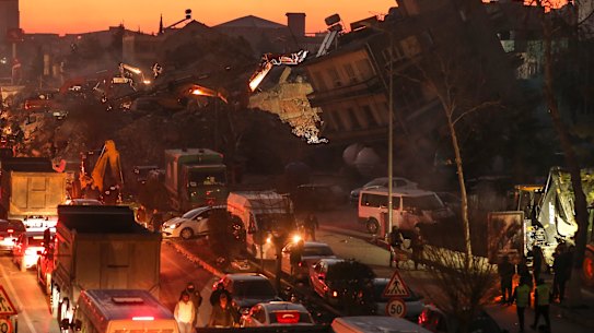 People walk among collapsed buildings, in Adiyaman. Emergency crews made a series of dramatic rescues in Turkey on Friday, pulling several people, some almost unscathed, from the rubble.