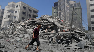 A man walks past the rubble of a building destroyed in an Israeli air strike in Gaza City.